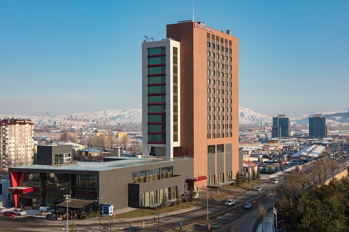 Hilton Garden Inn Sivas'ın gündüz görünümü, karlı dağlar eşliğinde